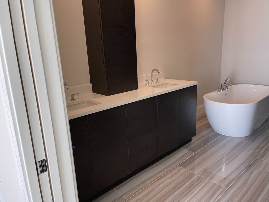 Bathroom with a dark double vanity and white freestanding soaking tub